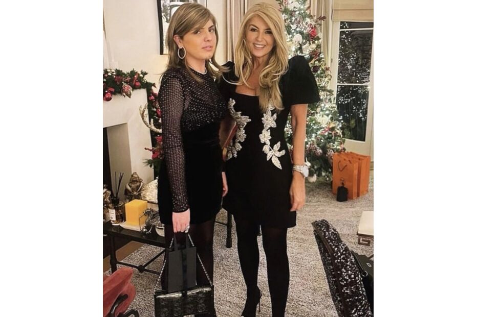 Duas mulheres posam para uma foto em frente a uma árvore de Natal decorada