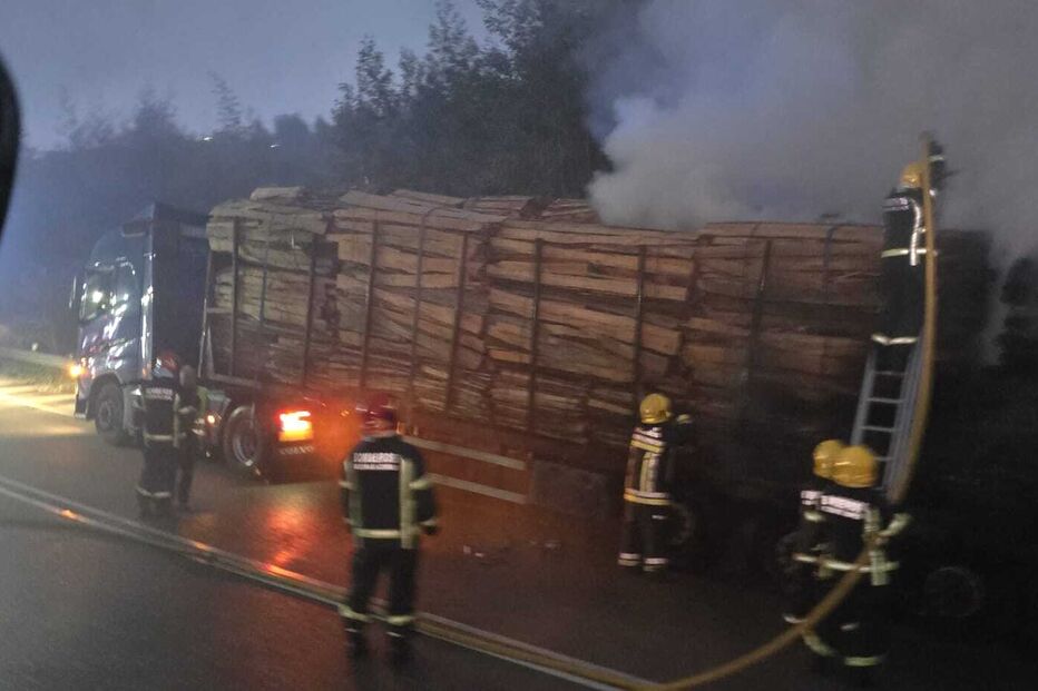Bombeiros combatem incêndio num camião carregado de madeira