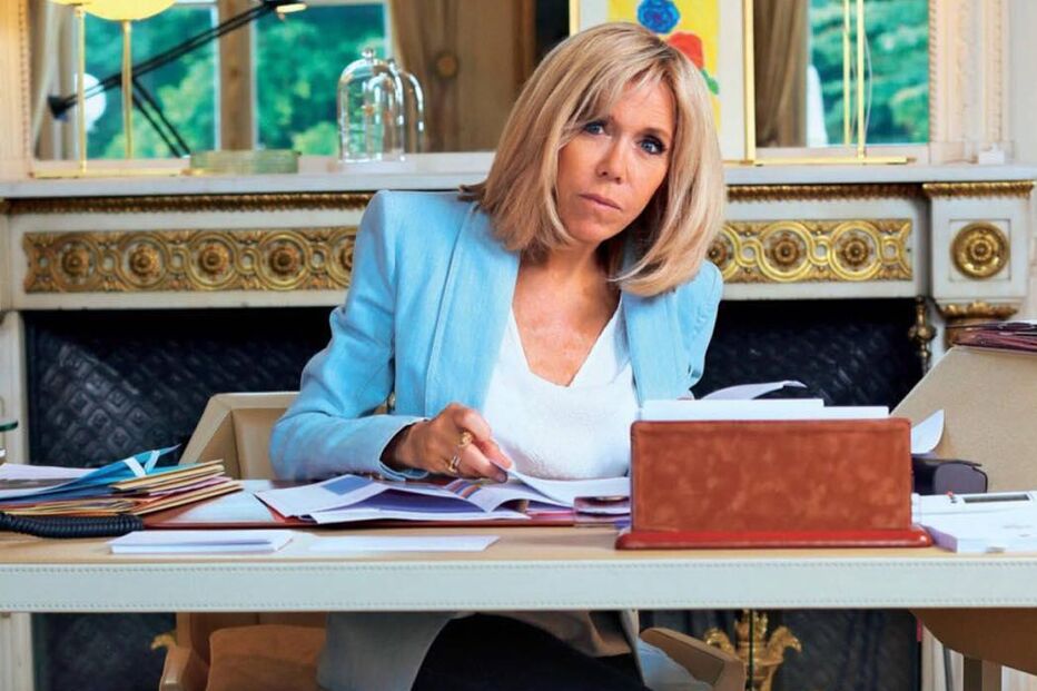Brigitte Macron sentada numa secretária num escritório
