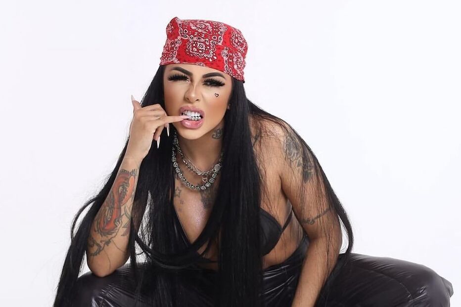 Mulher com bandana vermelha, tatuagens e calças largas posa