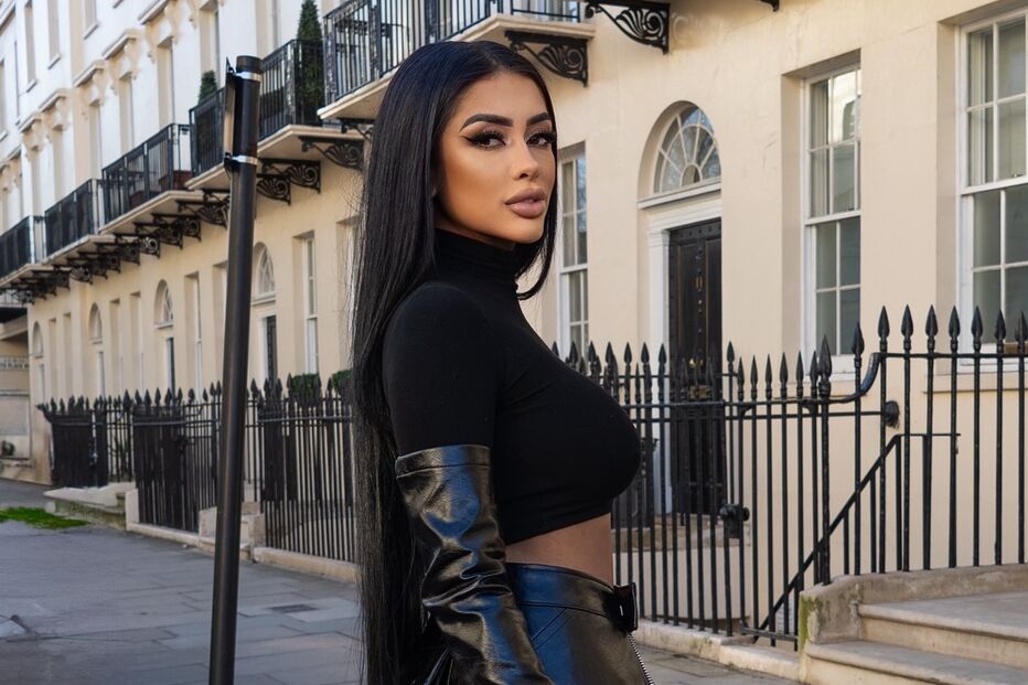 Uma mulher elegante posa com um conjunto preto sofisticado em Londres
