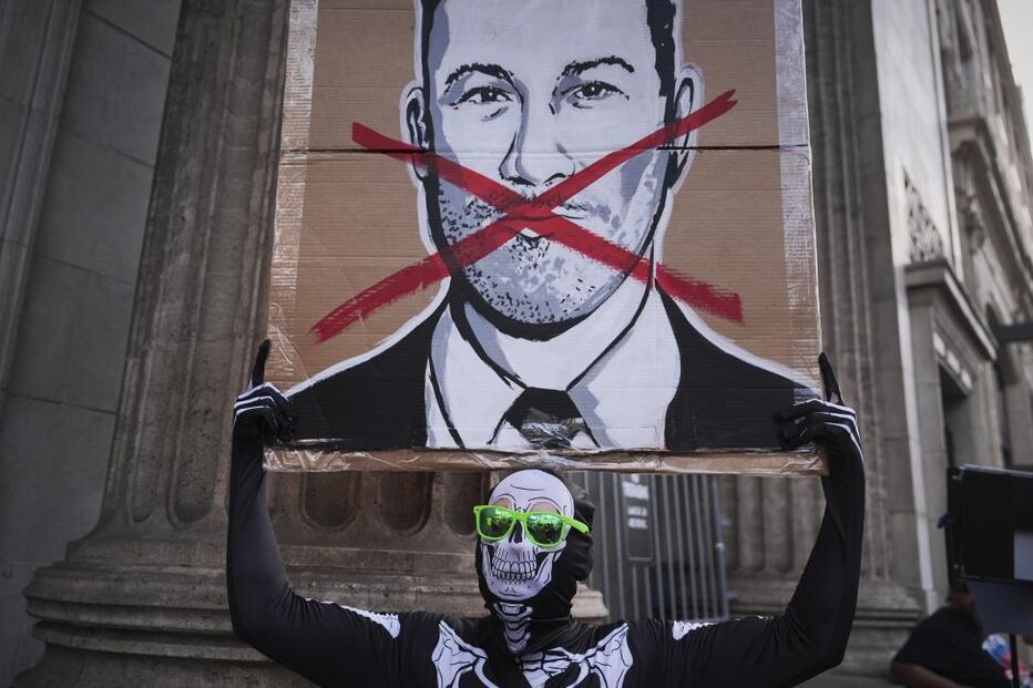 Protesto com pintura de Elon Musk riscada