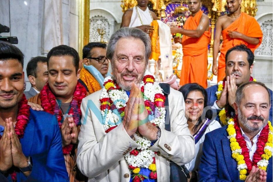 Visitantes cumprimentam num templo hindu com flores