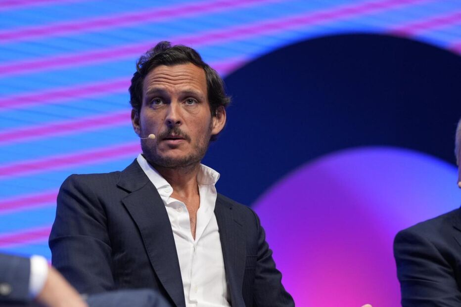 Um homem de fato e camisa branca num evento