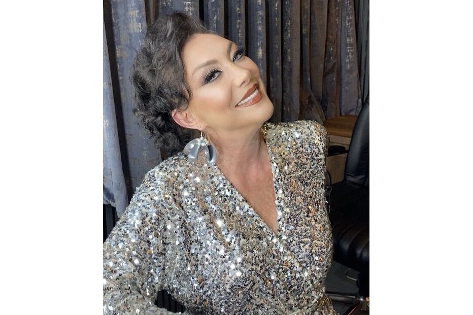 Mulher com um vestido brilhante posa para a foto