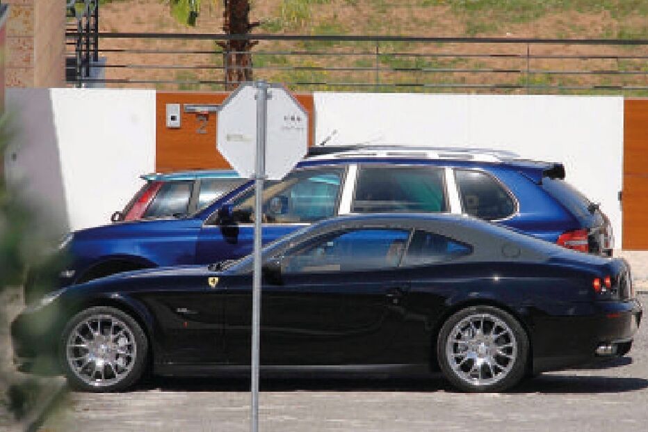 Estacionamento com Ferrari preto e outros carros