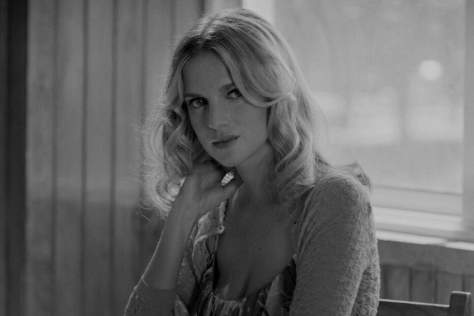 Retrato em preto e branco de uma mulher loira com cabelo ondulado