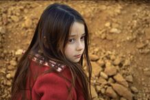 Menina olha para trás com casaco vermelho