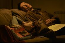 Casal descansa no sofá com livro 