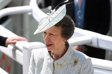 A princesa Ana num evento com um fato azul e um chapéu.
