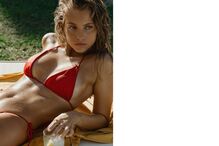 Mulher de biquíni vermelho descansa junto a um copo com uma bebida fresca