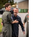 Frederico da Dinamarca abraça um piloto militar sorrindo