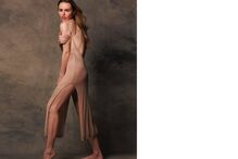 Modelo exibe vestido comprido e justo num estúdio