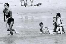 Família Kennedy nada na praia: um legado de união e esperança.
