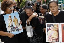 Pessoas mostram fotos da realeza tailandesa e lamentam