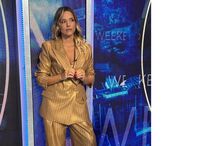 Mulher com fato dourado em frente a ecrã digital