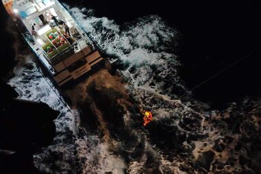 Momento em que a Força Aérea resgata a família acolhida no barco de pesca