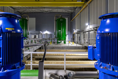 Interior de uma instalação industrial com tanques e motores azuis