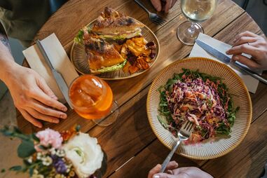 Almoço com sanduíche, salada e bebida entre amigos