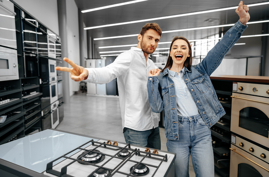 Casal feliz a comprar novos eletrodomésticos para a cozinha