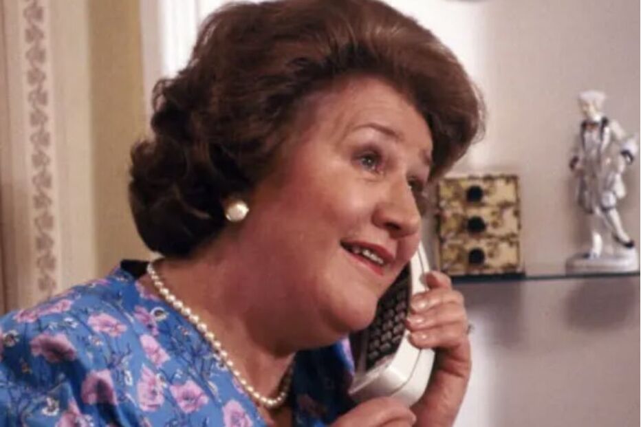 Patricia Routledge atende um telefone em cena