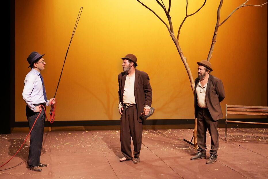 Peça com três atores em palco e uma árvore seca