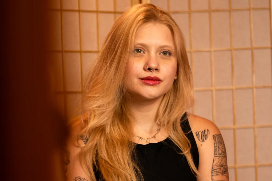 Retrato de mulher com tatuagens nos braços e cabelo comprido