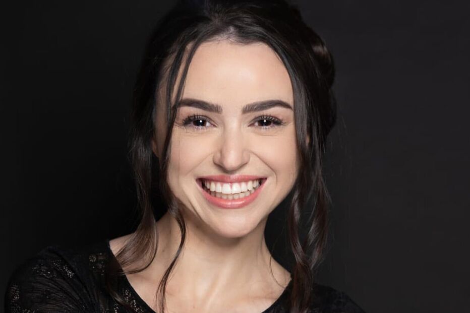 Uma mulher sorri com um vestido de renda preta