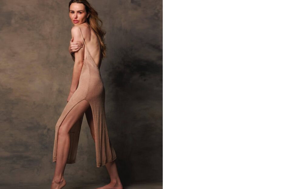 Modelo exibe vestido comprido e justo num estúdio