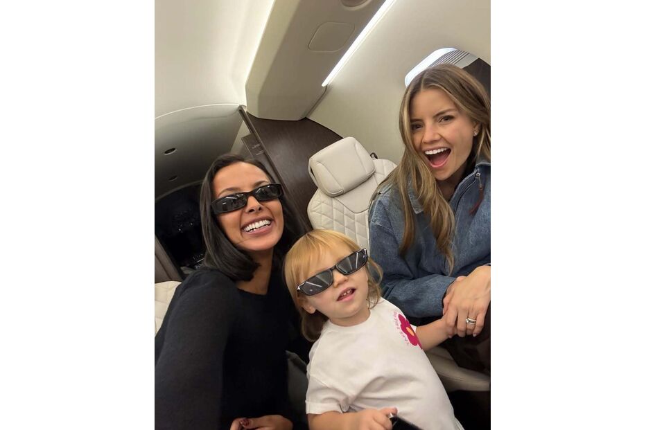 Três pessoas sorriem dentro de uma aeronave