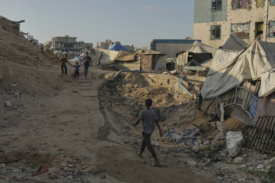 Após ofensiva israelita, crianças palestinianas caminham entre os escombros em Gaza