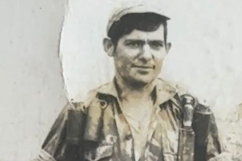 Um soldado em uniforme camuflado segura uma arma