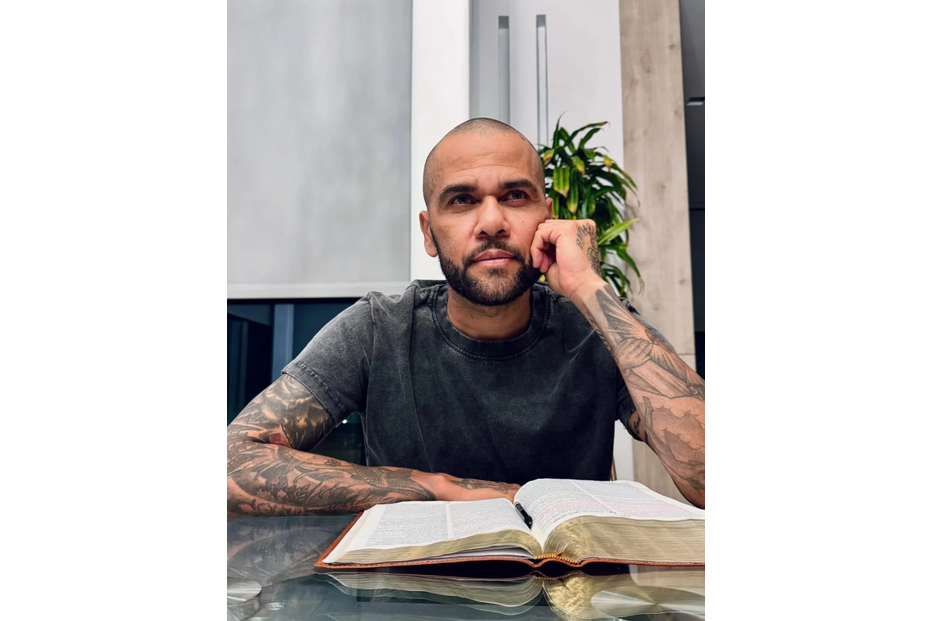 Dani Alves surge a ler um livro, após sair da prisão.
