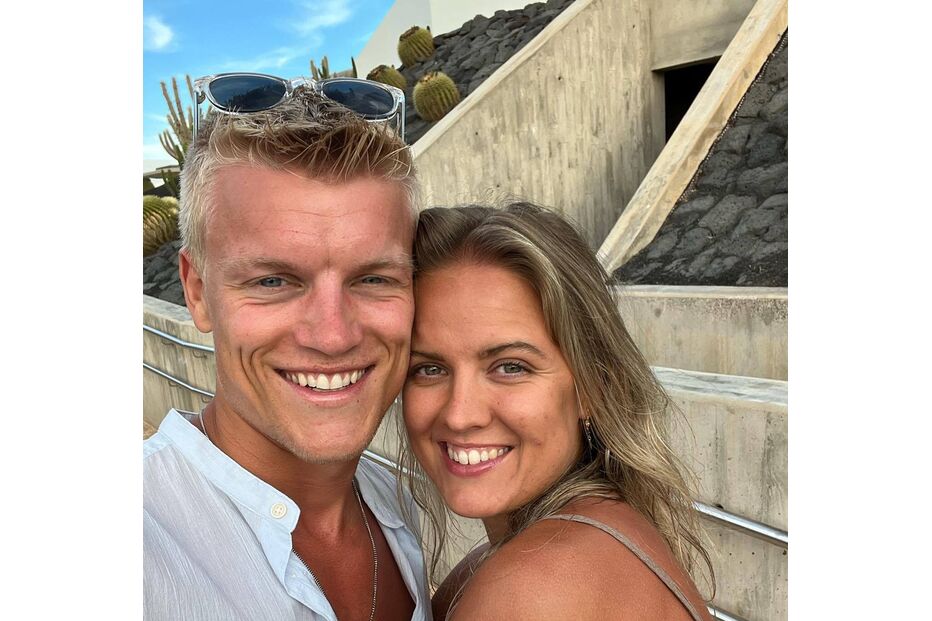 Um homem e uma mulher sorriem para a câmara