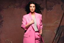 Mulher posa com fato rosa, elegância e estilo em destaque