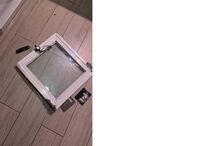 Porta de duche danificada no chão da casa de banho.
