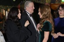 Kate Middleton num evento de caridade, com um vestido verde esmeralda