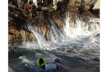 Mergulhadores em ação no mar, perto da costa rochosa
