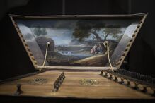 Instrumento musical com pintura de um rio e duas figuras