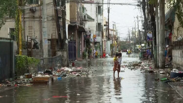 Habitantes atravessam rua inundada durante passagem de supertufão nas Filipinas
