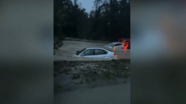 Carros praticamente submersos em estrada alagada em Sesimbra