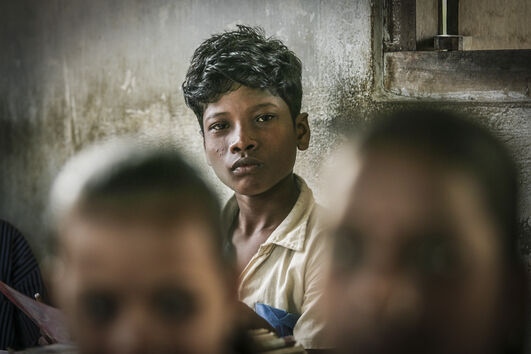 Rapaz bengali olha para a câmara, num país com católicos e emigração para Portugal