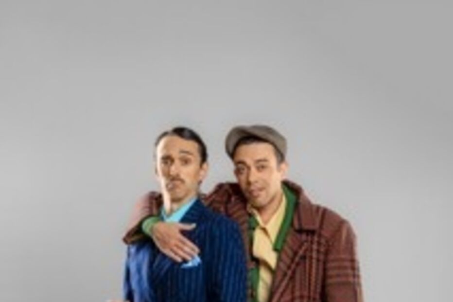 Dois homens posam com vestes clássicas e padrão xadrez