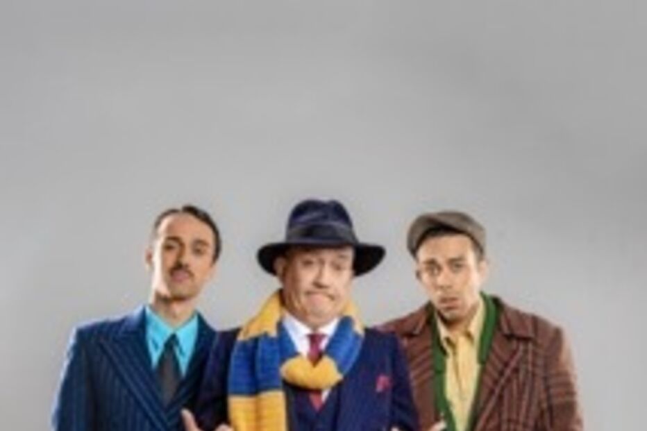 Três homens posam com fatos clássicos e chapéus, exibindo um estilo vintage