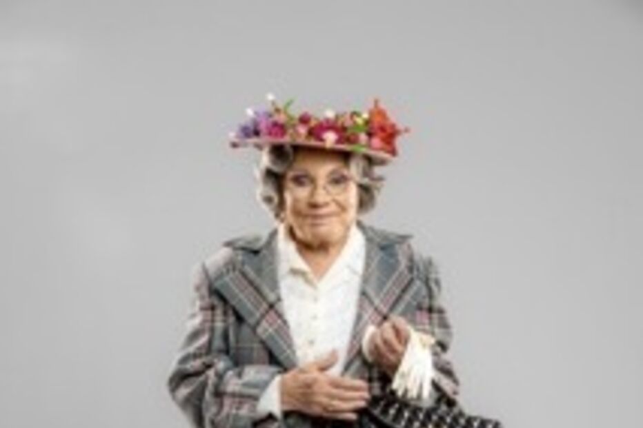 Atriz surge com visual característico, incluindo um chapéu floral