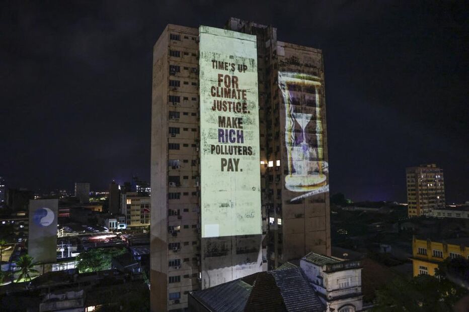 Projeção de uma frase ilumina edifício durante um protesto no final do primeiro dia da 30ª Conferência das Nações Unidas (COP30) 