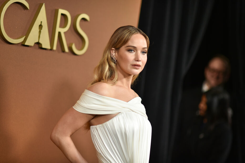 Jennifer Lawrence nos Óscares, com vestido branco e brincos vistosos