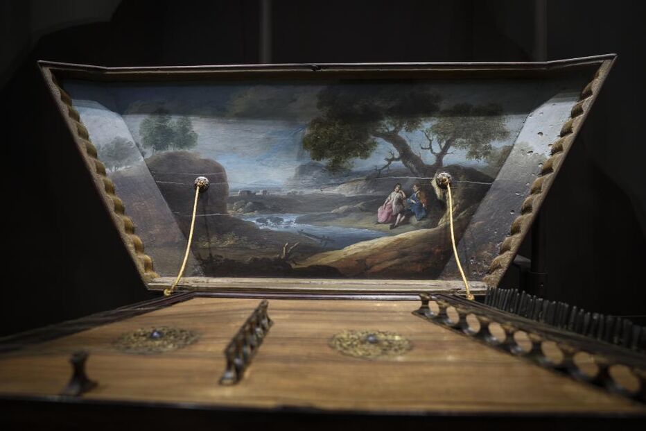 Instrumento musical com pintura de um rio e duas figuras