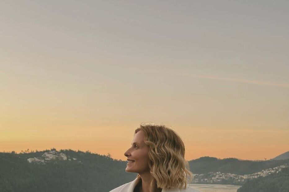 Cristina Ferreira relaxa no Douro com vista para o rio e montanhas ao pôr do sol.
