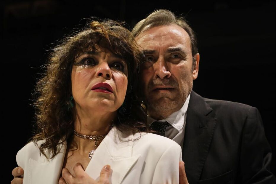 Atriz e ator representam cena emotiva numa peça de teatro